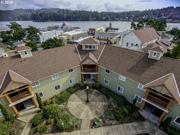 an aerial view of a house with a garden and lake view