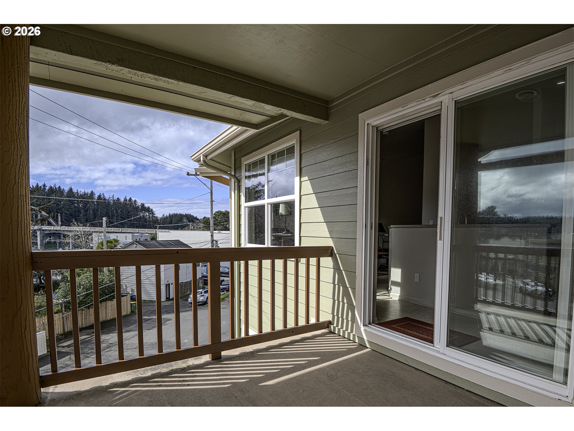 179 Laurel Street, Unit 9 Florence, OR 97439 - Photo 21 of 37 a view of a balcony with a floor to ceiling window and wooden floor