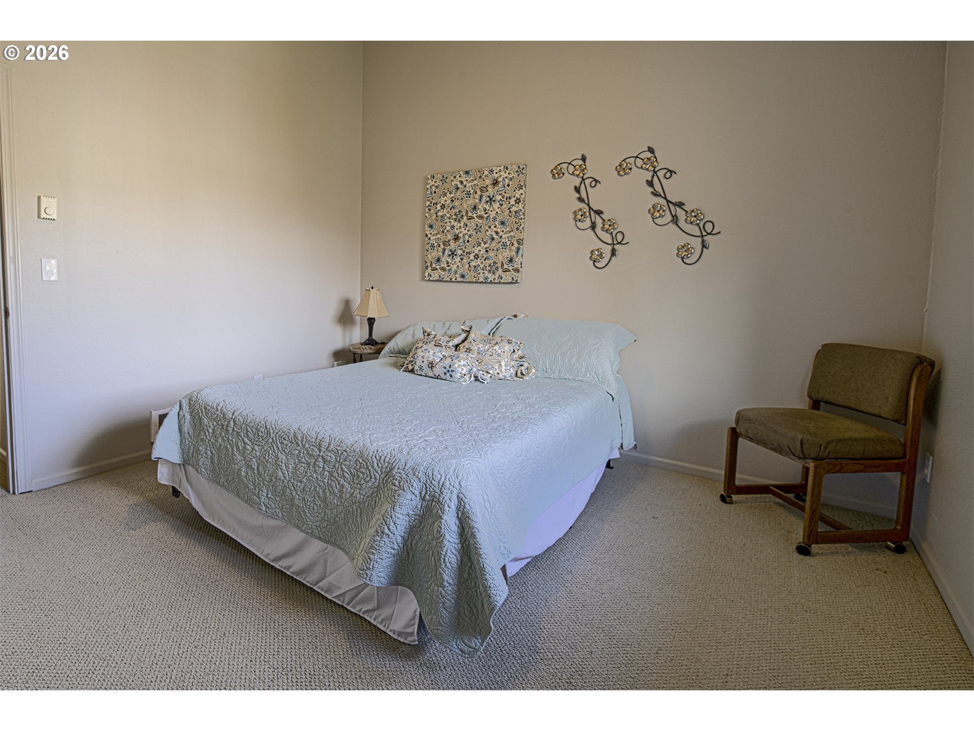 179 Laurel Street, Unit 9 Florence, OR 97439 - Photo 29 of 37 a bedroom with a bed and a chair