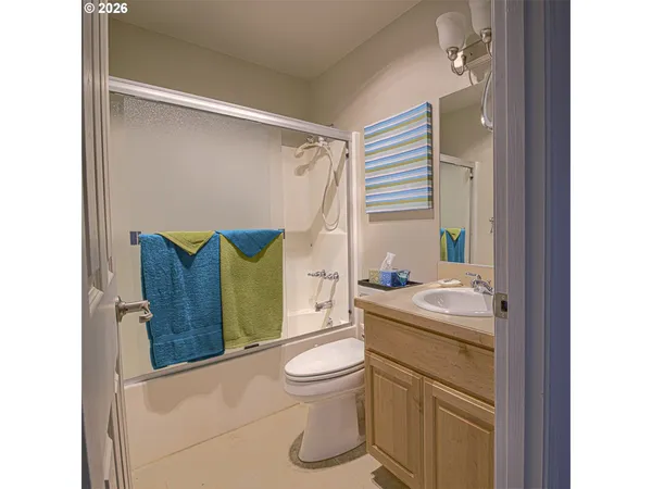 a bathroom with a toilet sink vanity tub and mirror