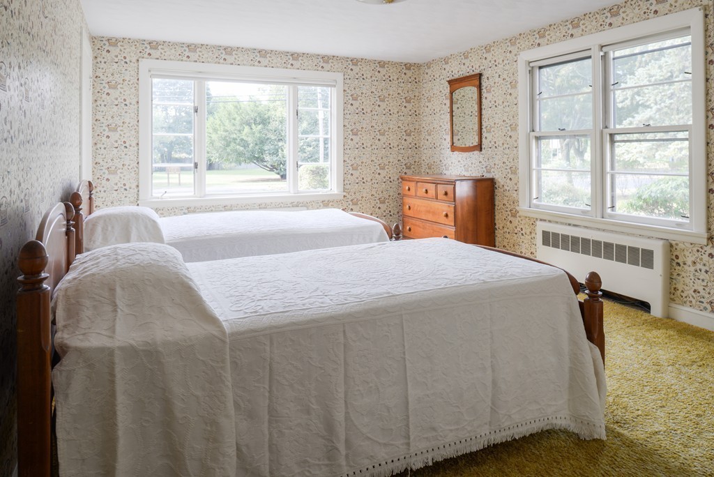 83 Lafayette Street Marblehead, MA 01945 - Photo 15 of 25 a bedroom with a bed a table and windows