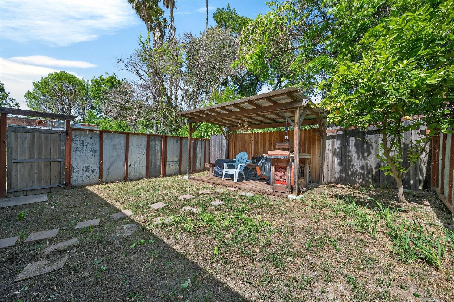 43 Main Street Isleton, CA 95641 - Photo 16 of 25 a view of a backyard with table and chairs under an umbrella with large tree