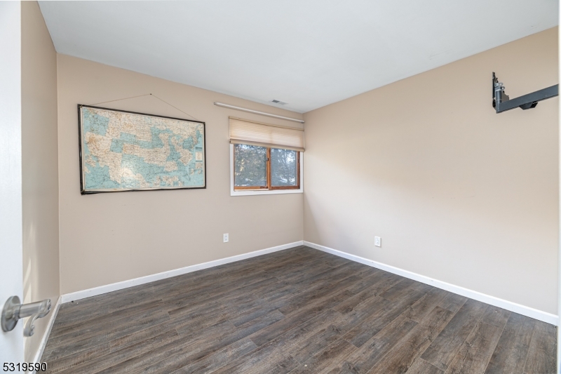 5 Sugar Loaf Court, Unit 7 Vernon, NJ 07462 - Photo 12 of 20 a view of an empty room with wooden floor and a window