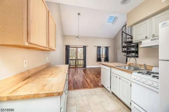 a large kitchen with kitchen island a sink stove and cabinets