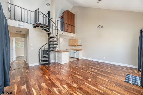 a view of a livingroom with wooden floor and staircase