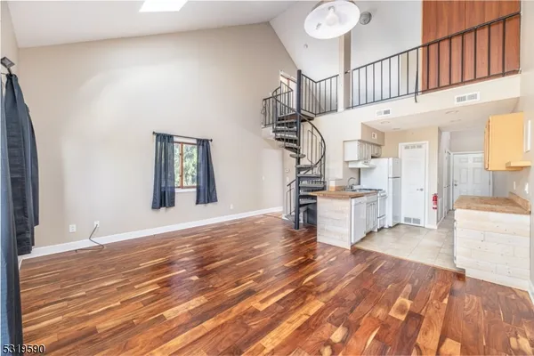 a view of a livingroom with wooden floor and staircase