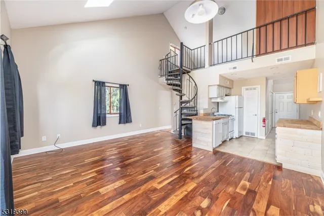 a view of a livingroom with wooden floor and staircase