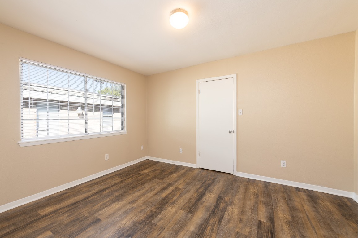 7300 Twin Crest Drive, Unit 202 Austin, TX 78752 - Photo 8 of 12 an empty room with wooden floor and windows