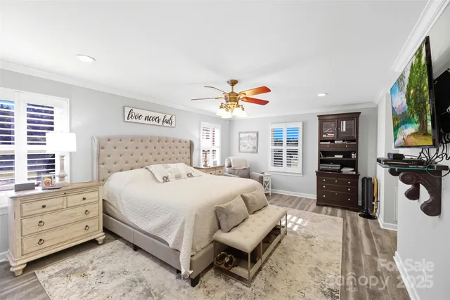 a bedroom with a large bed and a flat tv screen on dresser