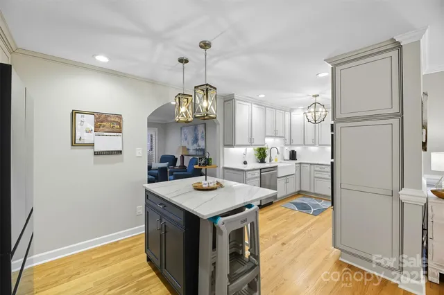 a kitchen with granite countertop a refrigerator a sink and a stove