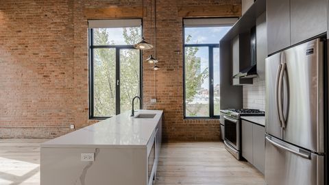 729 North Sangamon Street, Unit 401 Chicago, IL 60642 - Photo 3 of 38 a kitchen with stainless steel appliances granite countertop a refrigerator and a stove