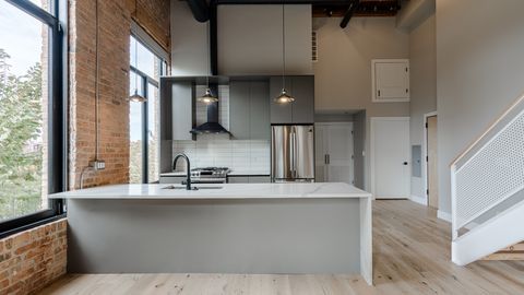 729 North Sangamon Street, Unit 401 Chicago, IL 60642 - Photo 6 of 38 a kitchen with kitchen island stainless steel appliances a sink and a window
