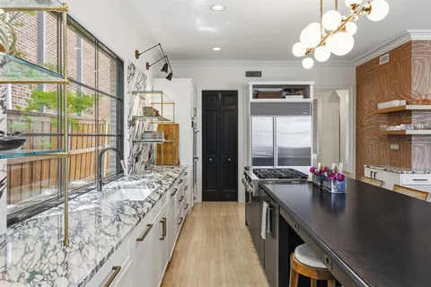 a kitchen with a counter space a sink appliances and a window