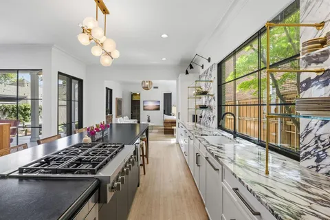 a large kitchen with stainless steel appliances granite countertop a stove and large cabinets
