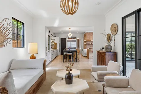 a living room with furniture a chandelier and a flat screen tv