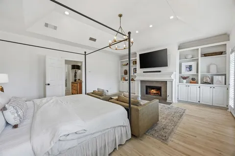 a spacious bedroom with a bed and a flat screen tv