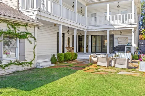 a view of a house with a yard patio and a fountain