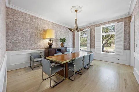a dining room with furniture a chandelier and wooden floor