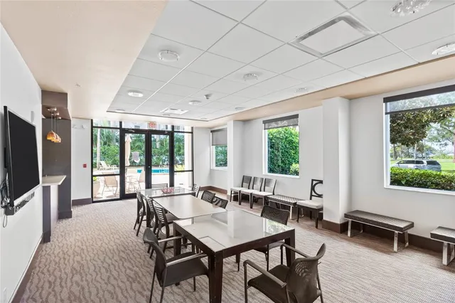 a living room with furniture a flat screen tv and a large window