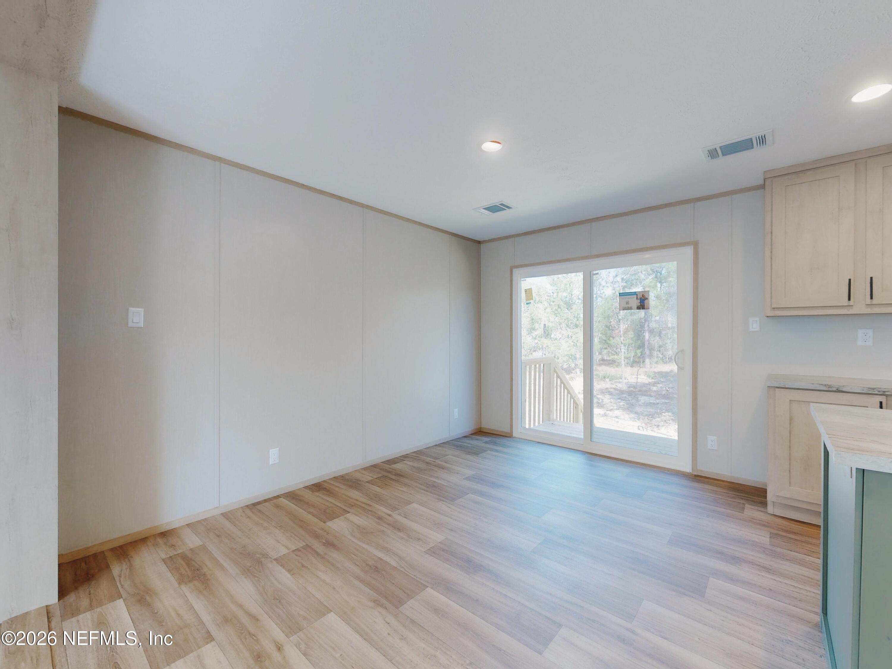 5770 Acadia Street Keystone Heights, FL 32656 - Photo 11 of 64 a view of an empty room with wooden floor and a window