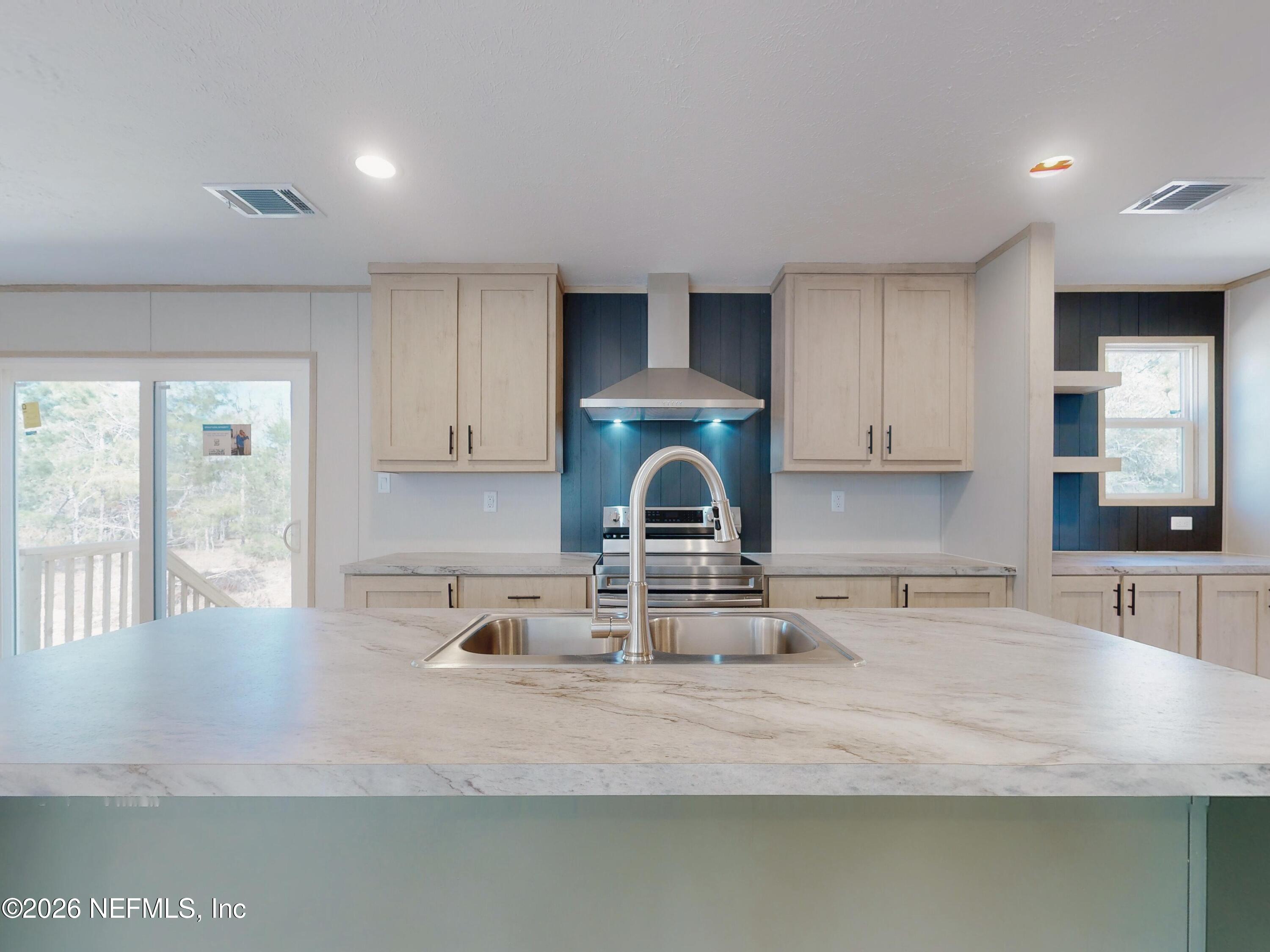5770 Acadia Street Keystone Heights, FL 32656 - Photo 12 of 64 a kitchen with kitchen island granite countertop a sink a stove and cabinets