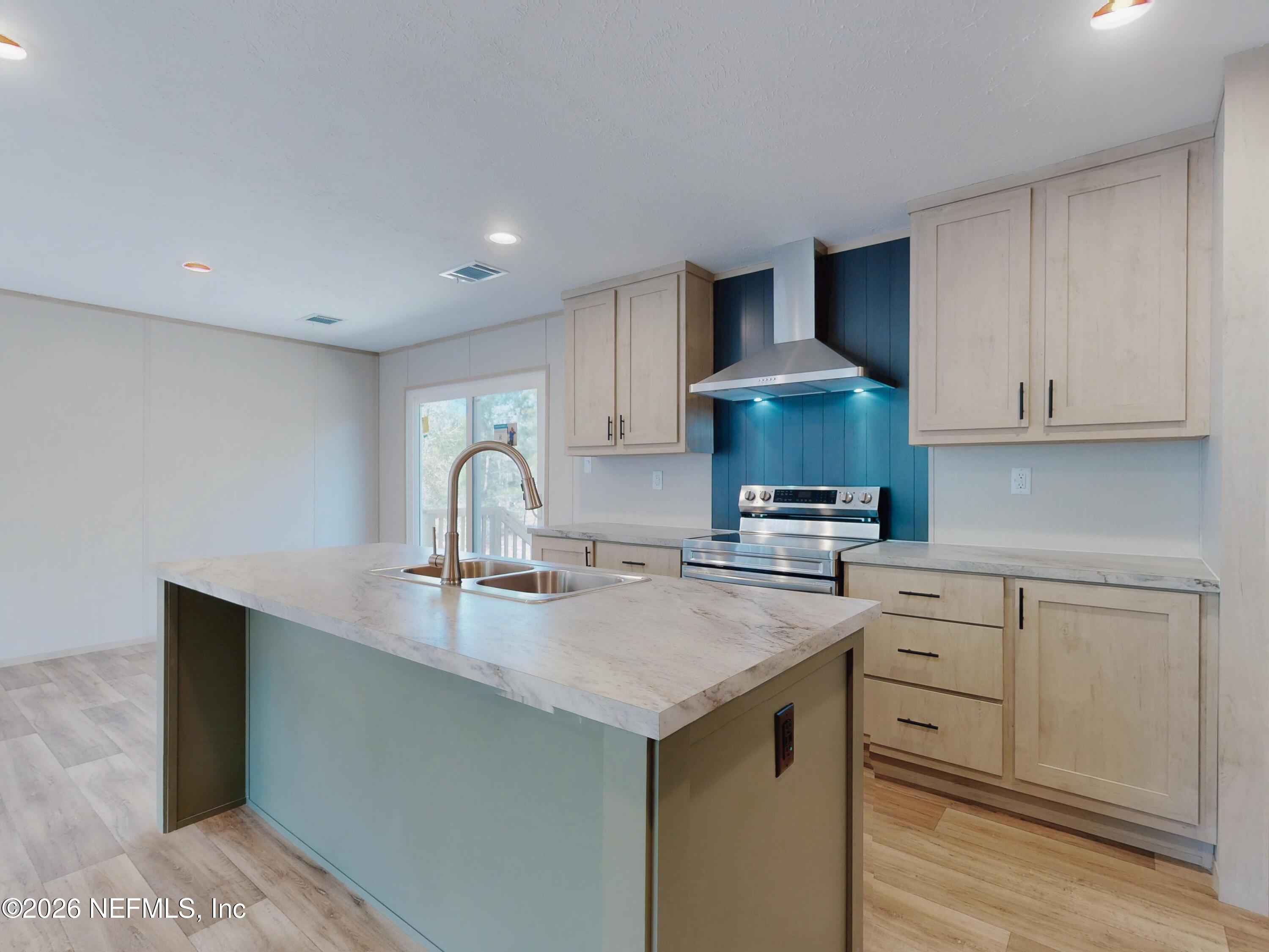 5770 Acadia Street Keystone Heights, FL 32656 - Photo 21 of 64 a kitchen with stainless steel appliances granite countertop a sink stove and cabinets