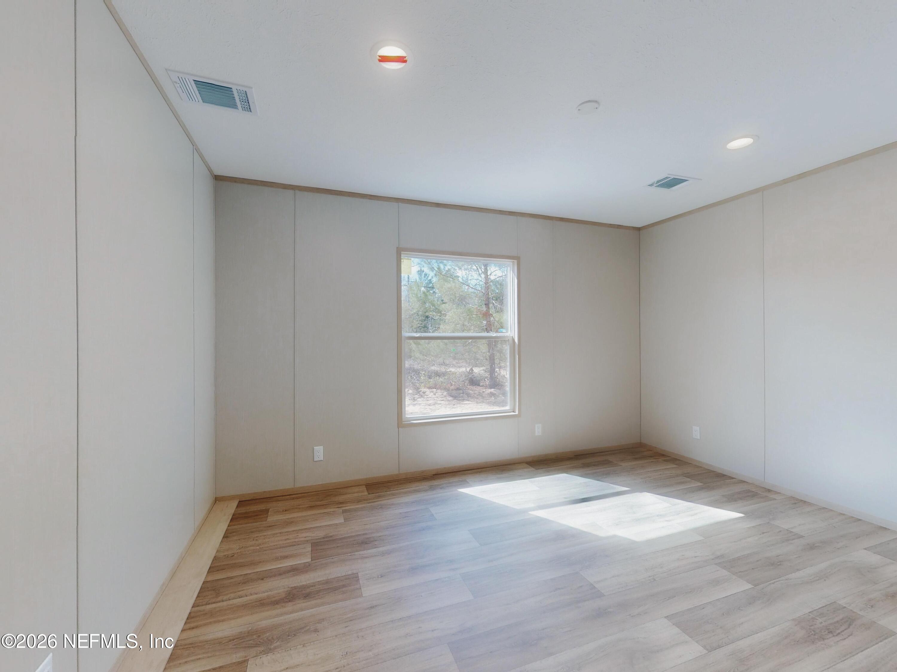 5770 Acadia Street Keystone Heights, FL 32656 - Photo 27 of 64 an empty room with wooden floor and windows