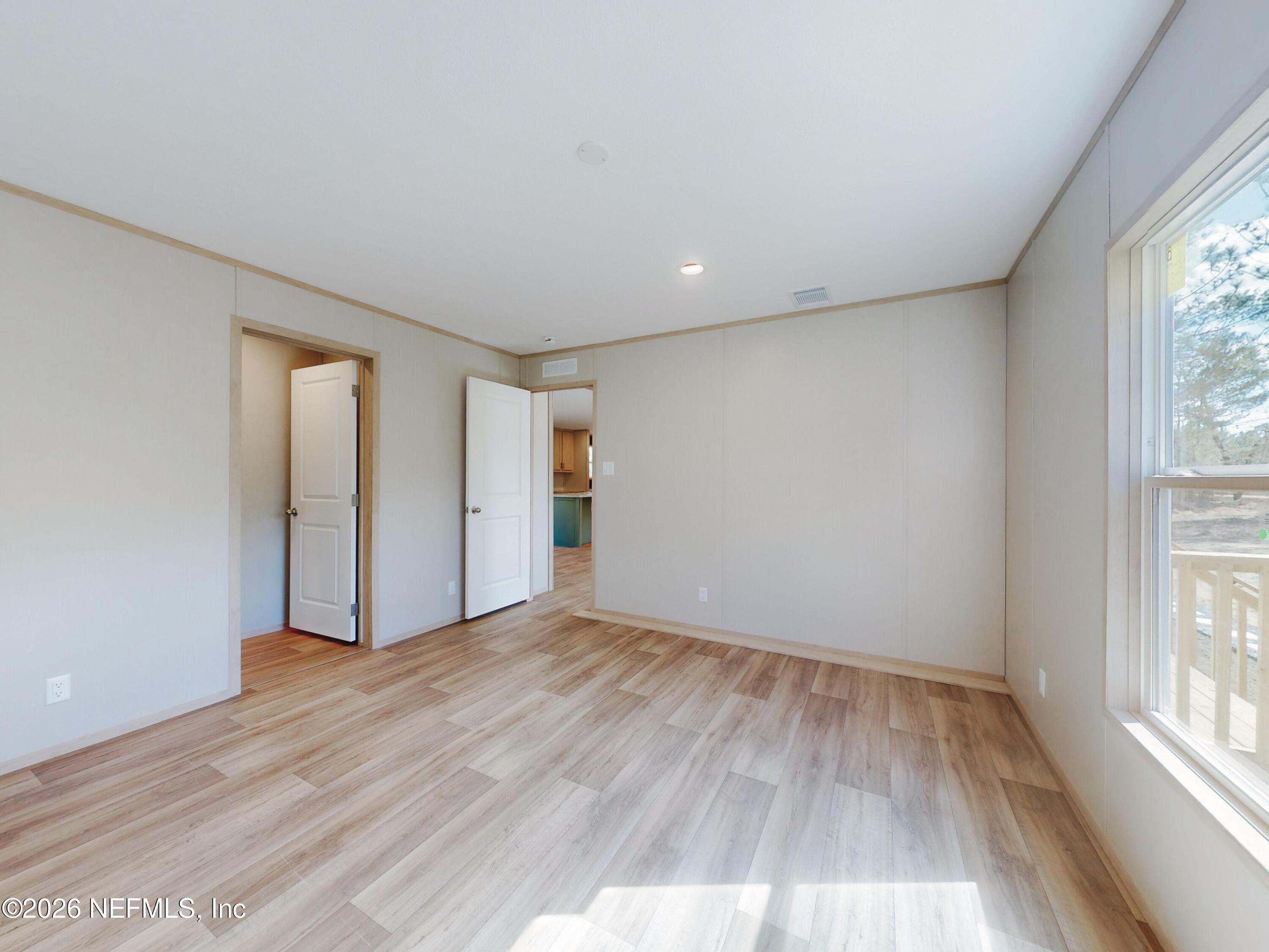 5770 Acadia Street Keystone Heights, FL 32656 - Photo 29 of 64 an empty room with wooden floor and windows