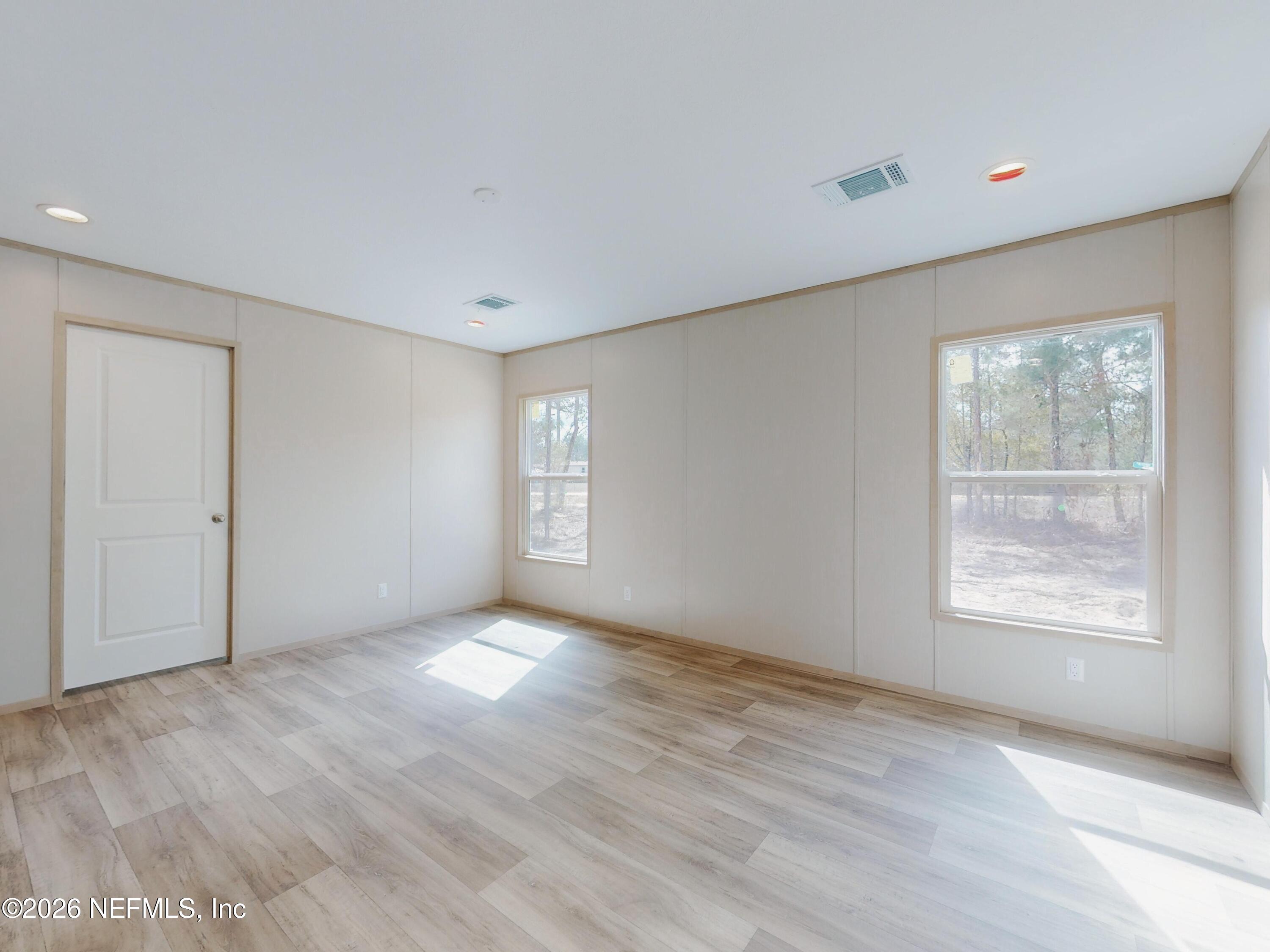 5770 Acadia Street Keystone Heights, FL 32656 - Photo 39 of 64 a view of an empty room with wooden floor and a window