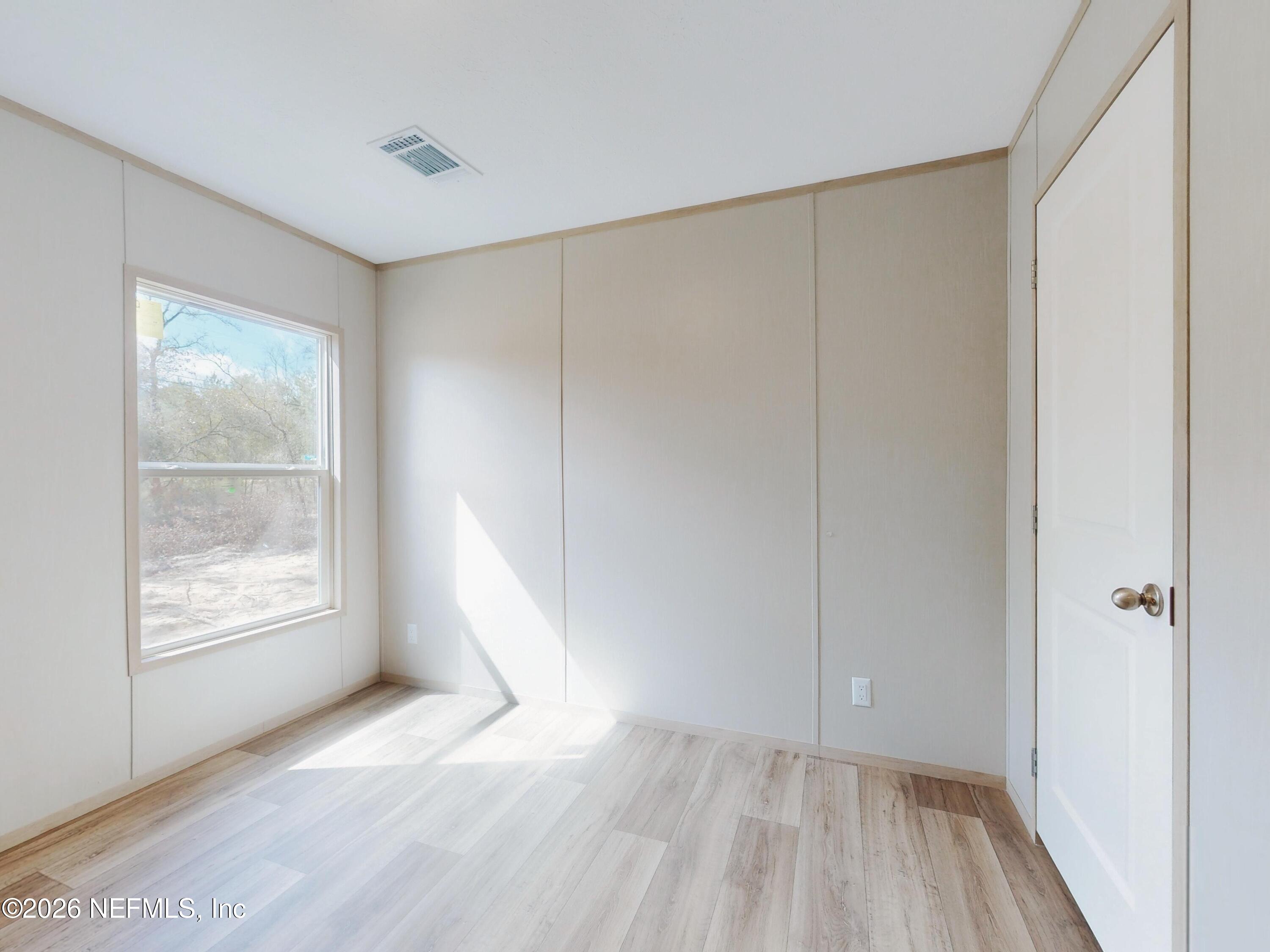 5770 Acadia Street Keystone Heights, FL 32656 - Photo 41 of 64 a view of an empty room with wooden floor and a window