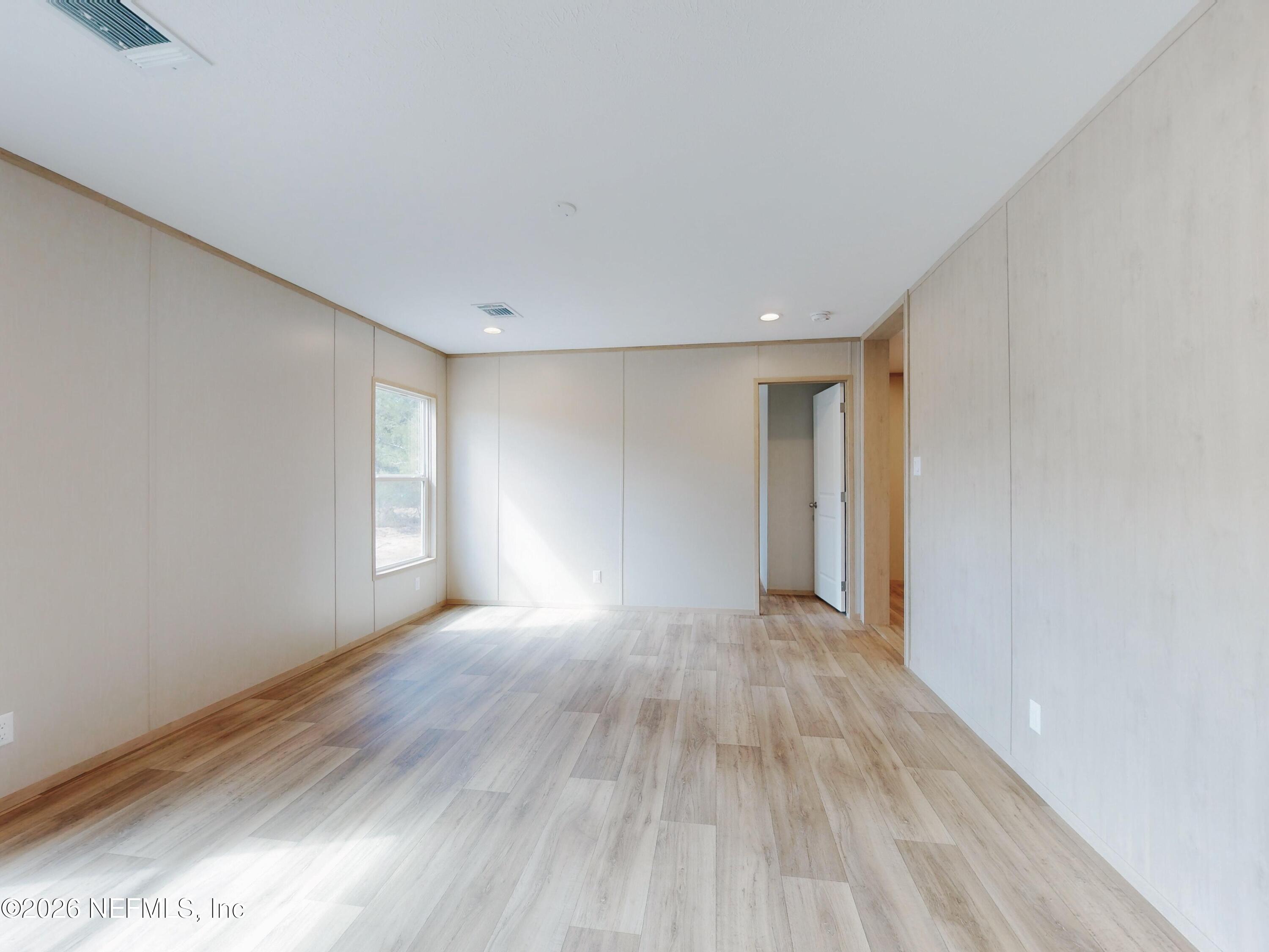 5770 Acadia Street Keystone Heights, FL 32656 - Photo 44 of 64 a view of an empty room with wooden floor and a window