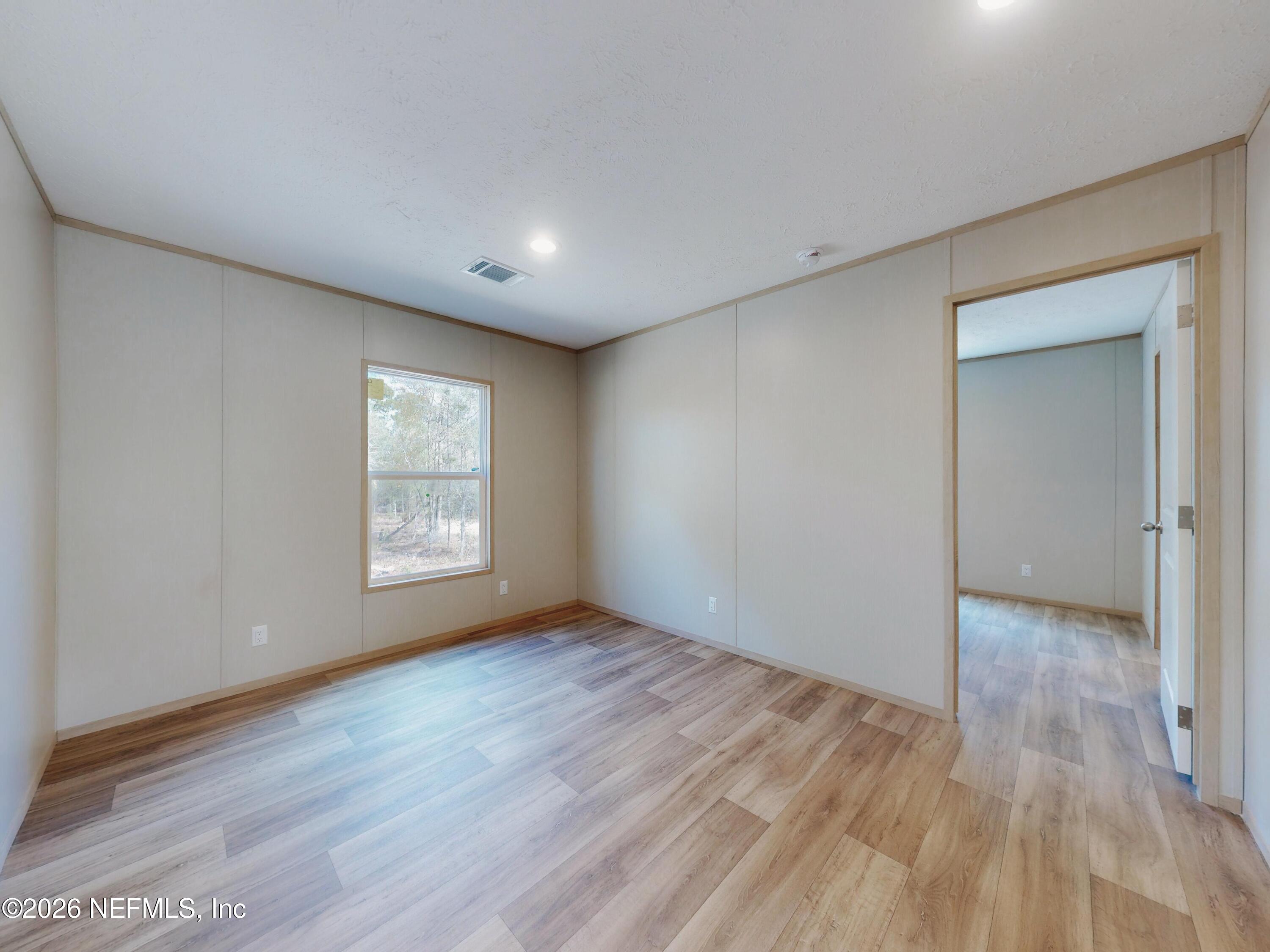 5770 Acadia Street Keystone Heights, FL 32656 - Photo 46 of 64 a view of an empty room with wooden floor and a window