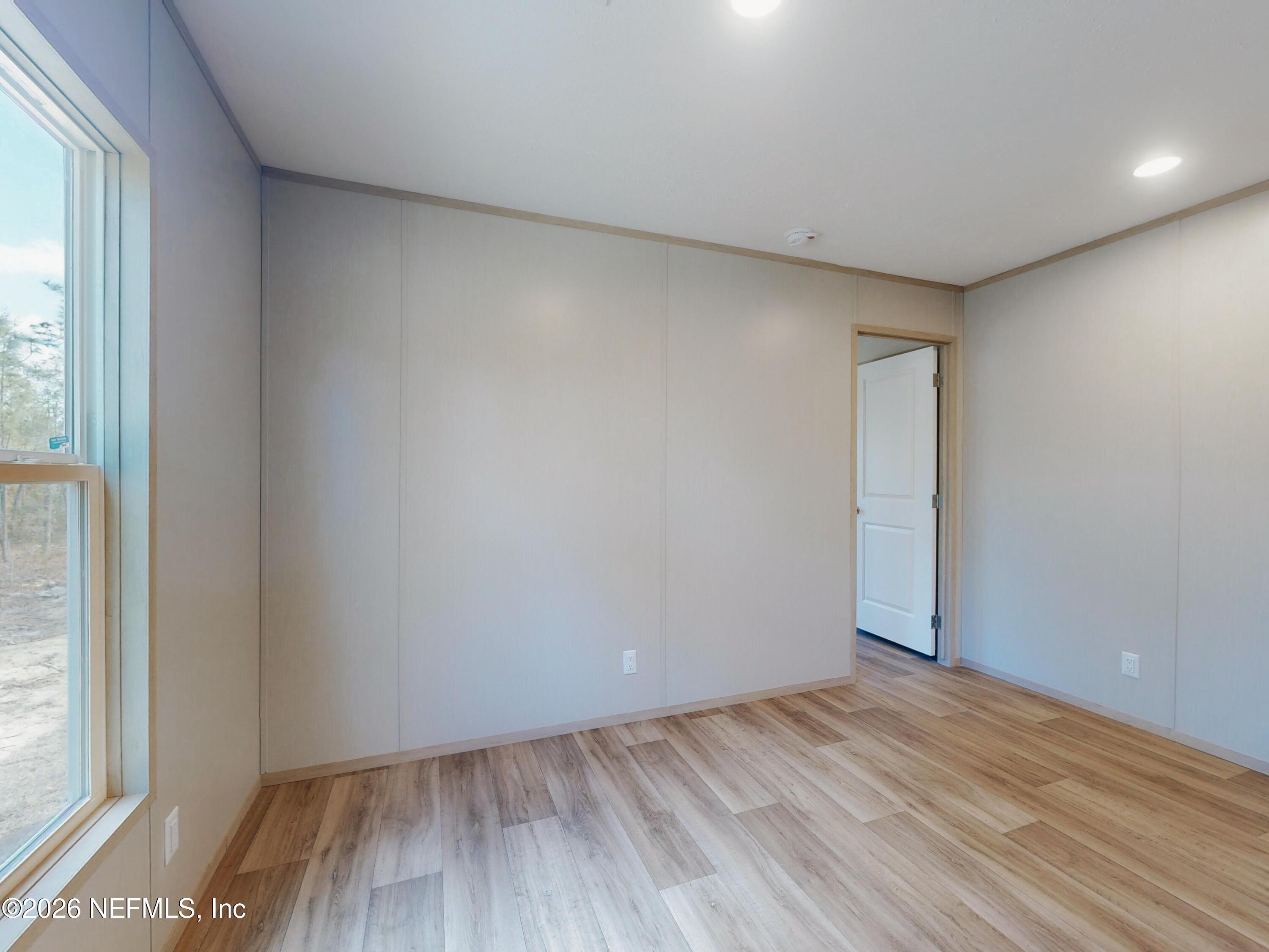 5770 Acadia Street Keystone Heights, FL 32656 - Photo 50 of 64 a view of an empty room with wooden floor and a window