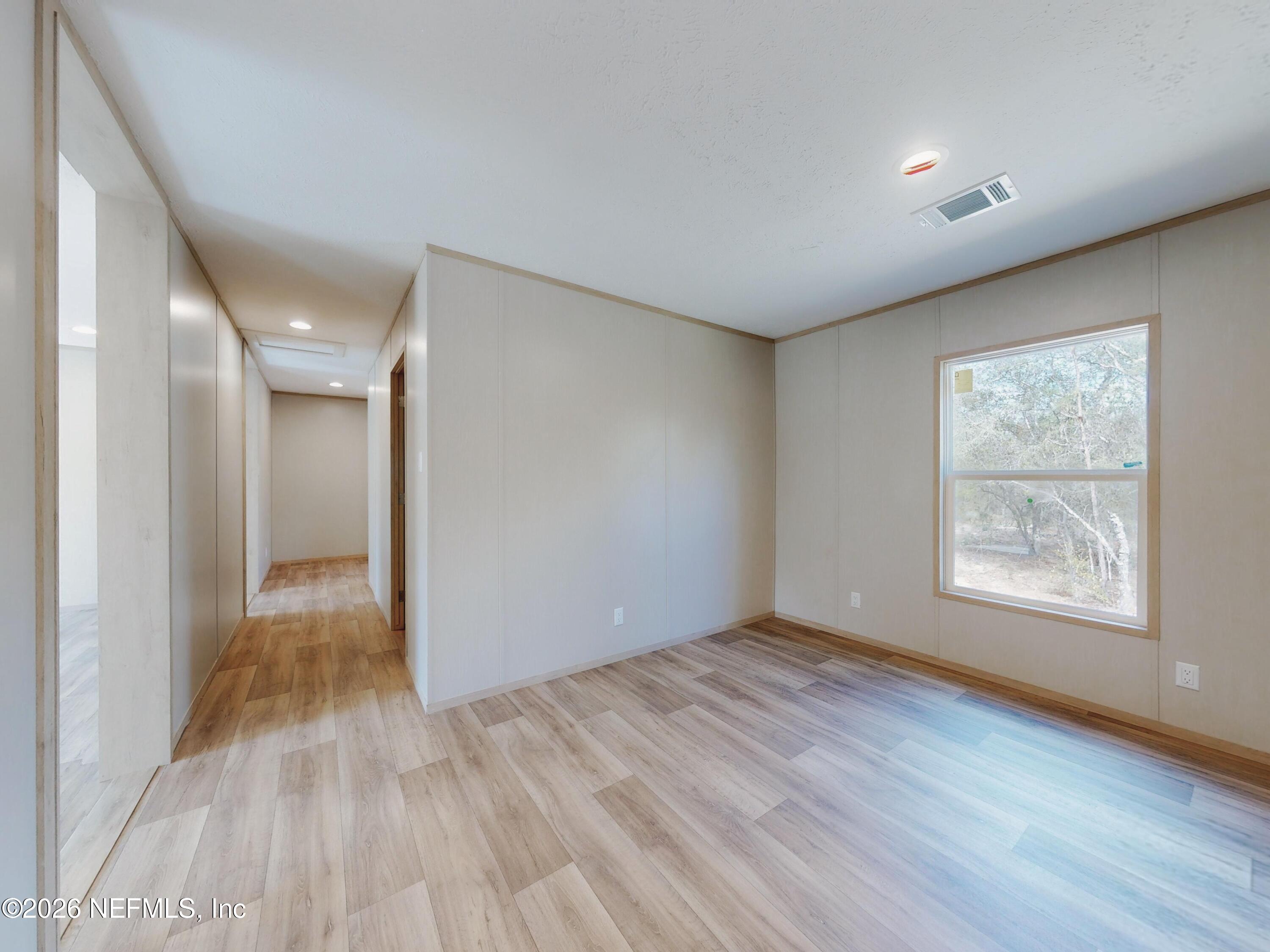 5770 Acadia Street Keystone Heights, FL 32656 - Photo 51 of 64 a view of an empty room with wooden floor and a window