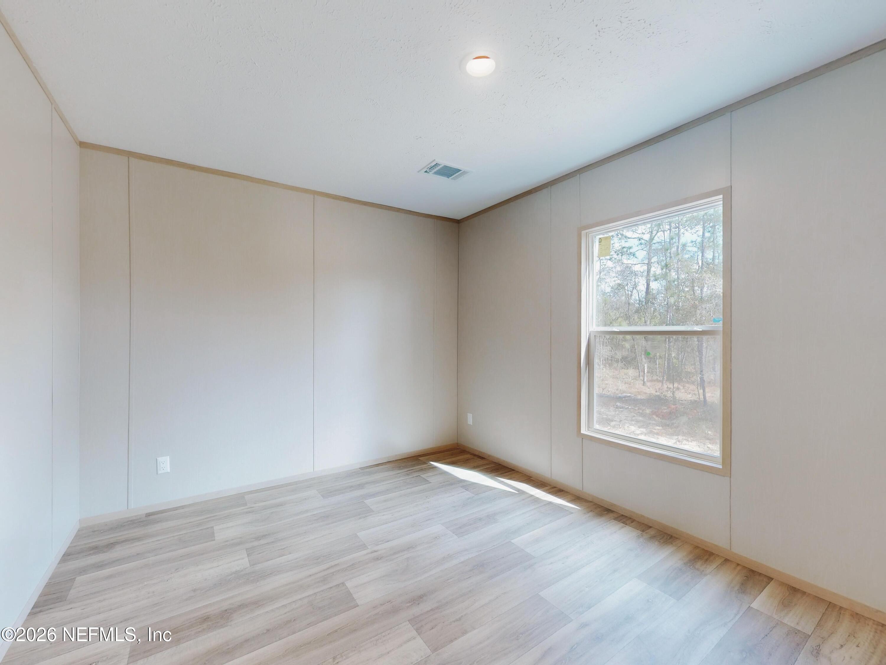 5770 Acadia Street Keystone Heights, FL 32656 - Photo 52 of 64 an empty room with wooden floor and windows