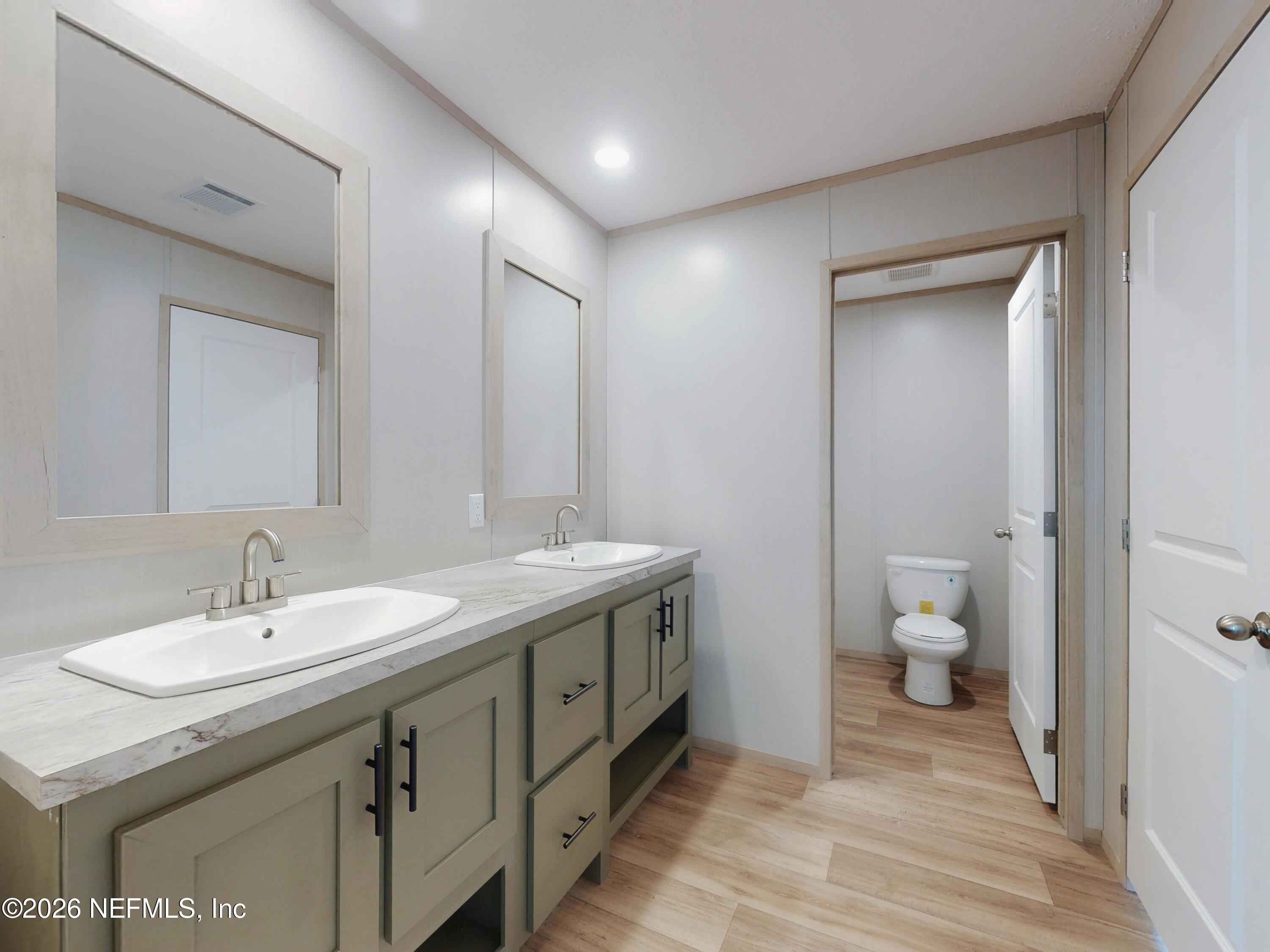 5770 Acadia Street Keystone Heights, FL 32656 - Photo 55 of 64 a spacious bathroom with a granite countertop sink and a toilet