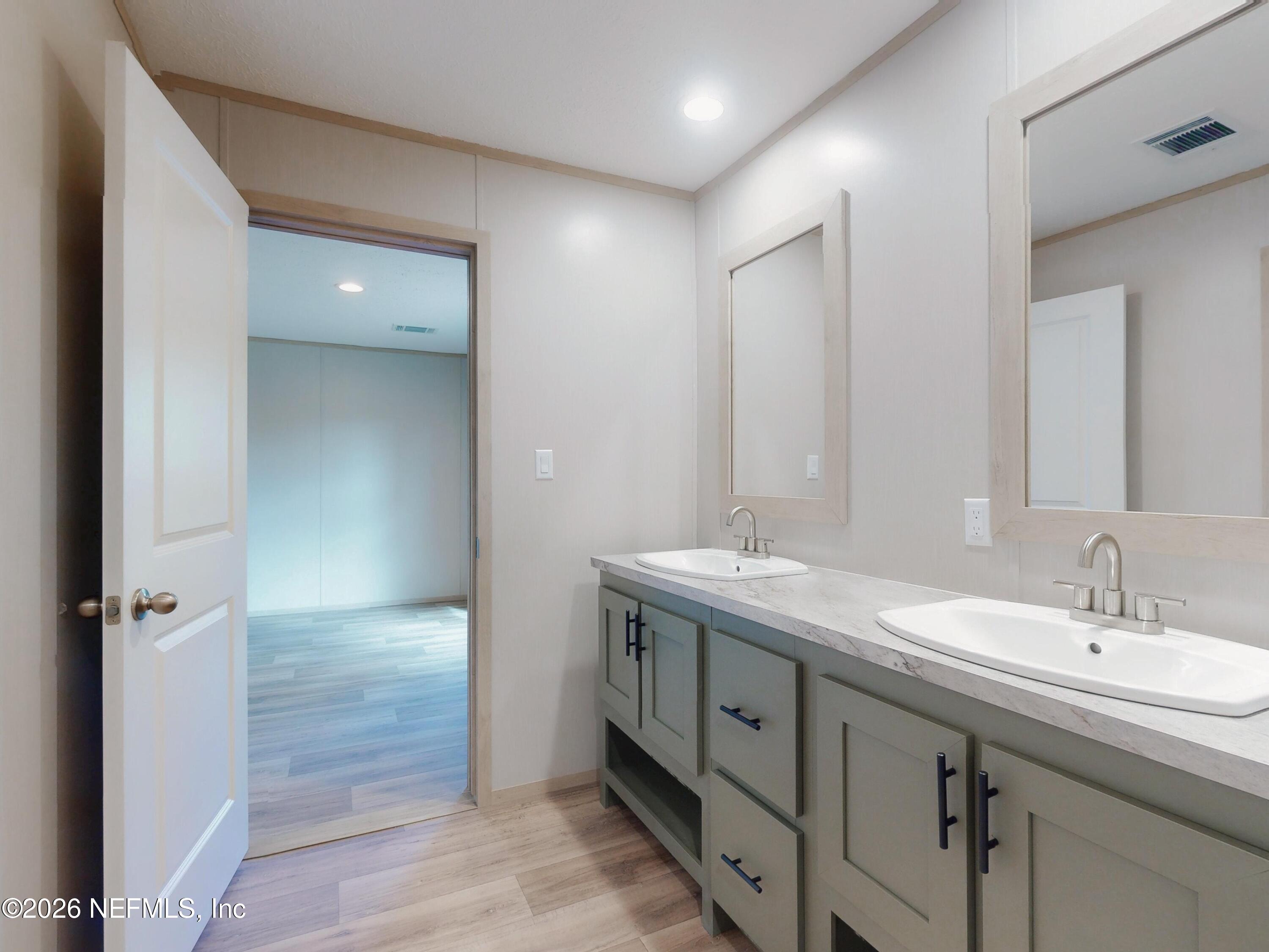 5770 Acadia Street Keystone Heights, FL 32656 - Photo 57 of 64 a bathroom with a granite countertop sink a large mirror and a shower