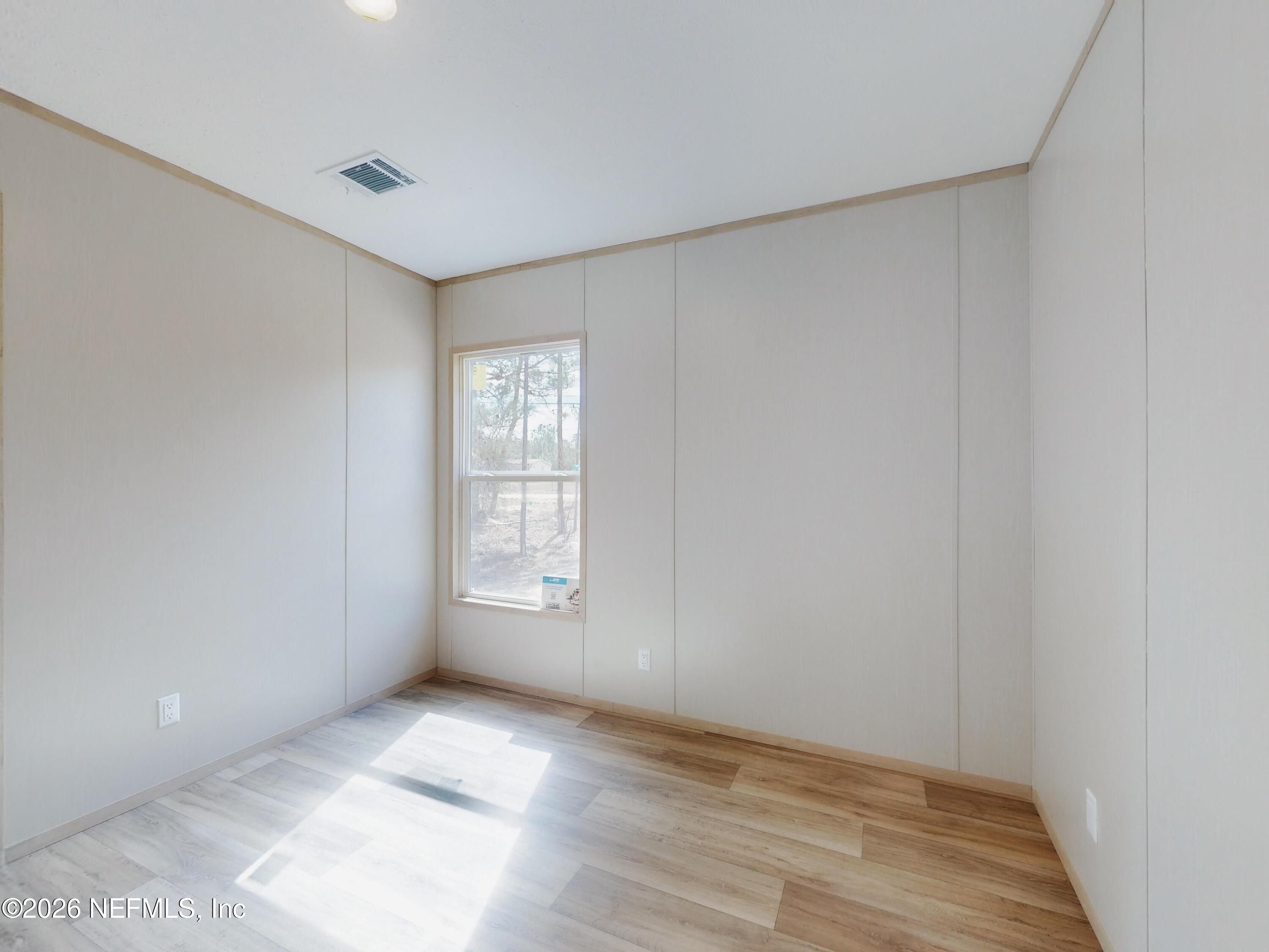5770 Acadia Street Keystone Heights, FL 32656 - Photo 60 of 64 a view of an empty room with wooden floor and a window