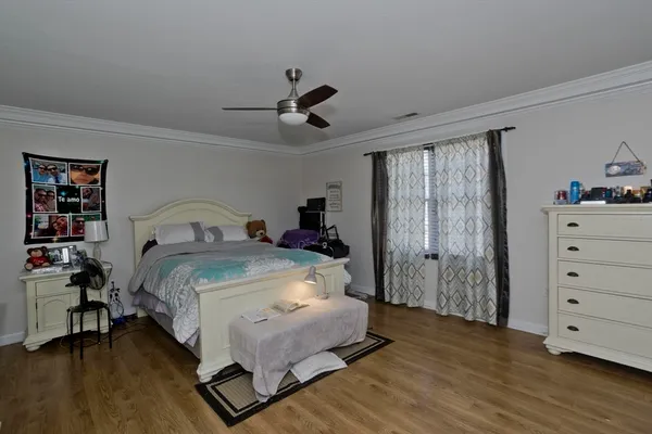a bedroom with a bed and wooden floor