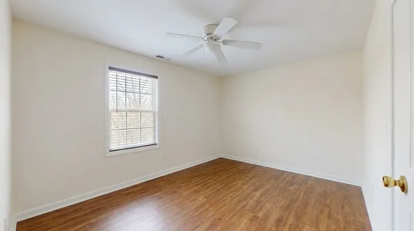 an empty room with a window and wooden floor