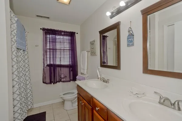 a bathroom with a granite countertop sink toilet and mirror