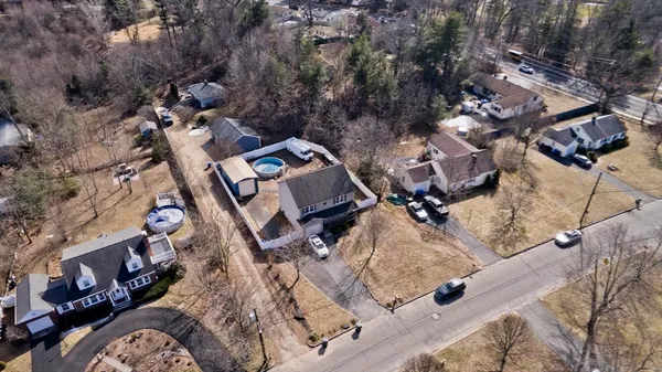 an aerial view of a house with a yard and parking