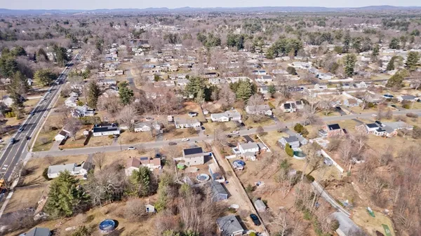 an aerial view of residential houses with outdoor space and trees