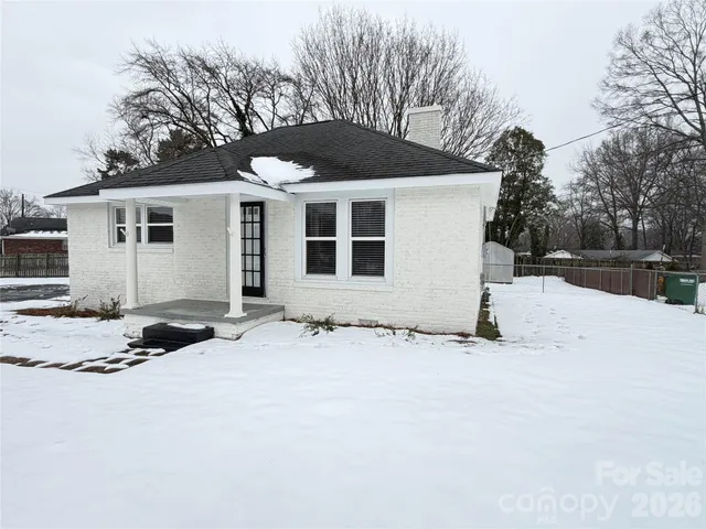 a front view of a house with a yard covered in snow