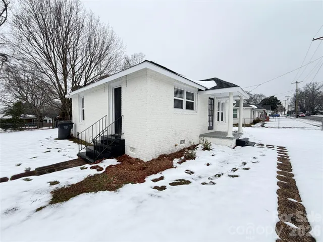 a white house that has a tree in front of it