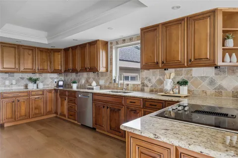 a kitchen with stainless steel appliances granite countertop wooden cabinets a sink and dishwasher