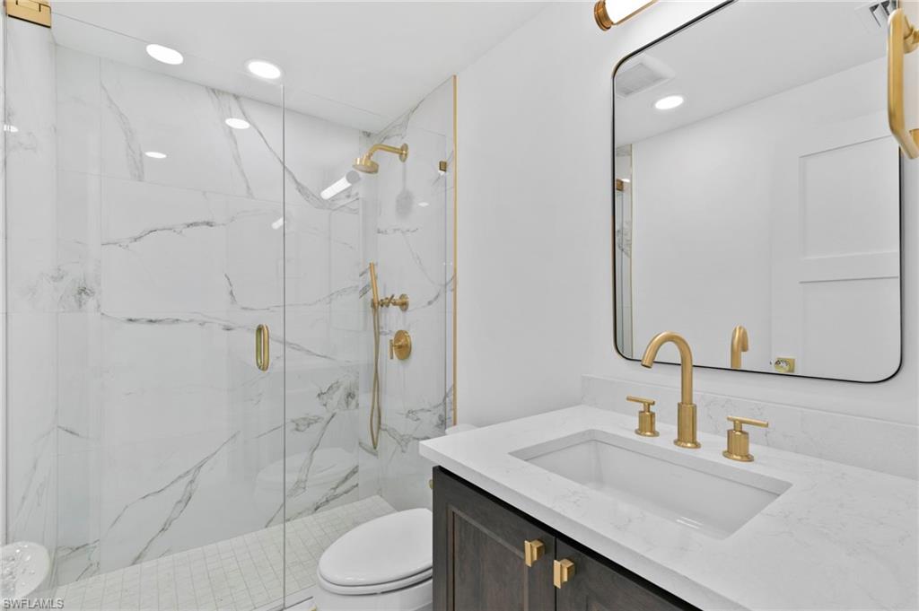 17 Knights Bridge Road Naples, FL 34112 - Photo 15 of 18 a bathroom with a sink a toilet and shower