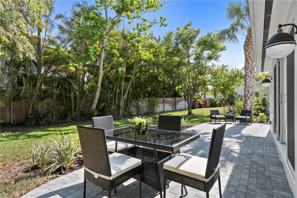 17 Knights Bridge Road Naples, FL 34112 - Photo 18 of 18 a view of a patio with table and chairs potted plants and a large tree