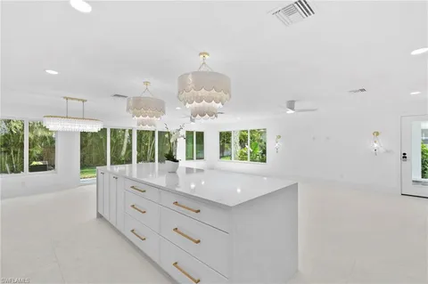 an open kitchen with granite countertop a stove and a white kitchen island