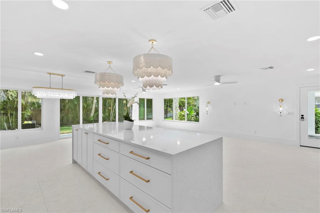 17 Knights Bridge Road Naples, FL 34112 - Photo 3 of 18 an open kitchen with granite countertop a stove and a white kitchen island